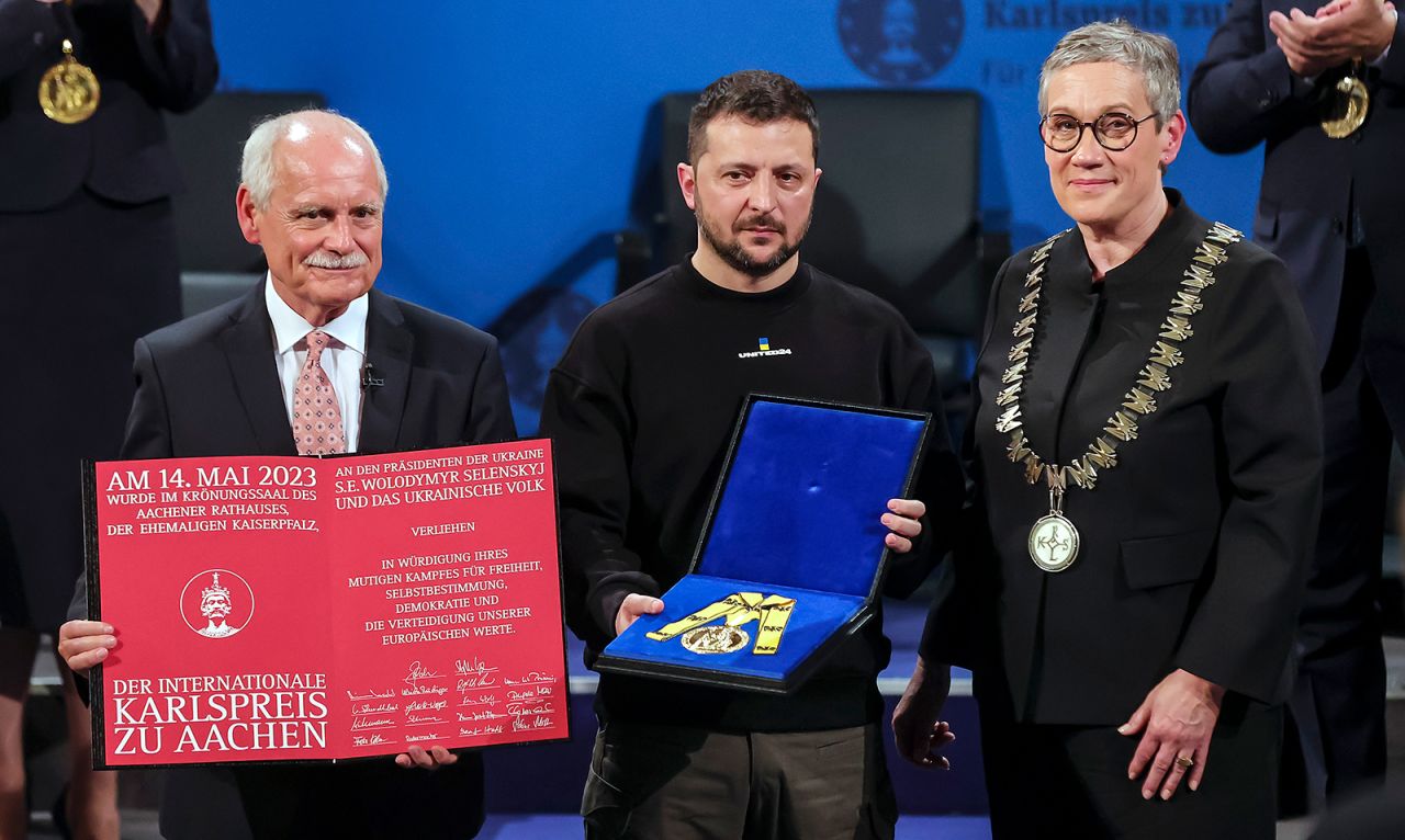 Ukrainian President Volodymyr Zelensky, center, holds the Charlemagne Prize on May 14, in Aachen, Germany.?