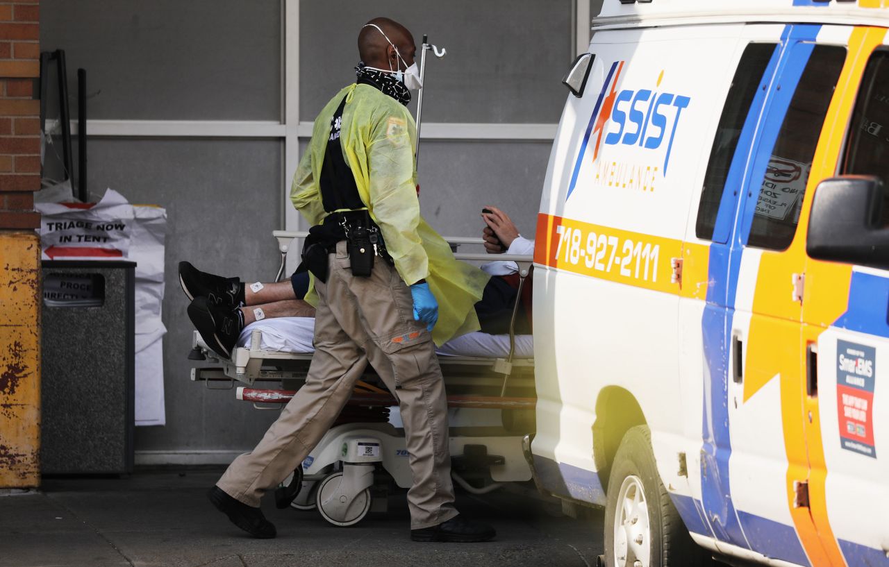 A medical worker transports a patient at a coronavirus intake area at Maimonides Medical Center on April 12, in the Brooklyn borough of New York City. 