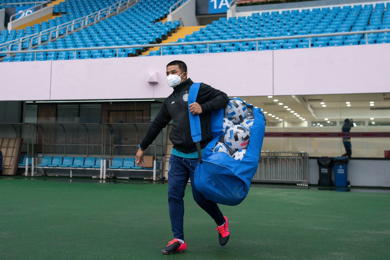 Before the announcement today to postpone games involving four Chinese clubs, a staff of Buriram United wearing a mask walks into the stadium during a training session prior to the AFC Champions League Preliminary Round match between Shanghai SIPG and Buriram United at Yuanshen Stadium on January 27, 2020 in Shanghai, China. Shanghai SIPG played Buriram United before an empty stadium due to the spread of the new coronavirus.