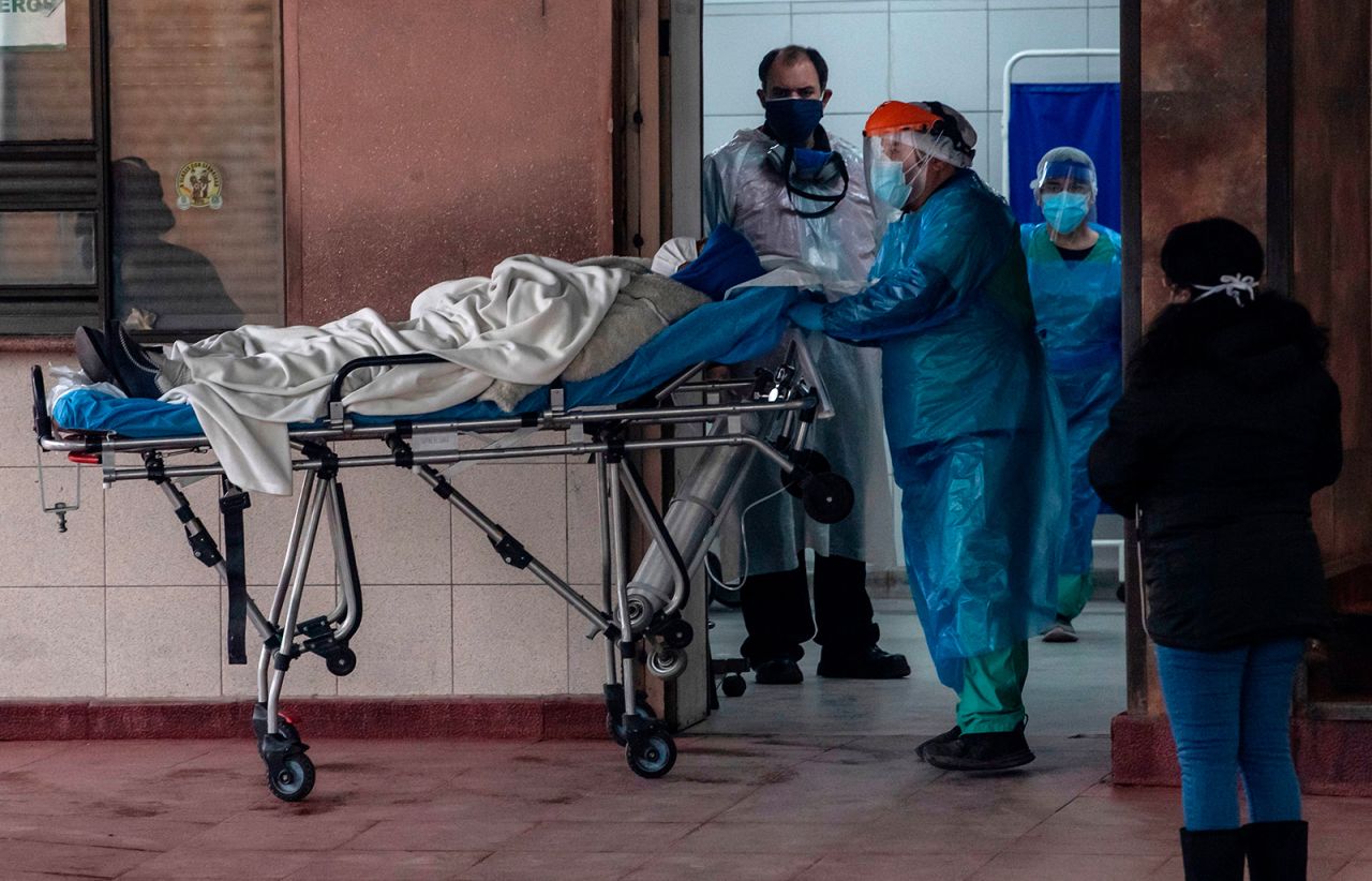 Health personnel transfer a patient with symptoms of the new COVID-19 coronavirus after being admitted at a hospital in Santiago, Chile, on June 18.