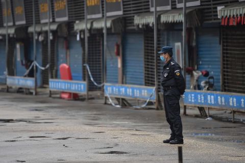 A security guard stands outside the Huanan Seafood Wholesale Market in Wuhan on January 24. Chinese health authorities closed the market after it was discovered that wild animals sold there may be the source of the virus.