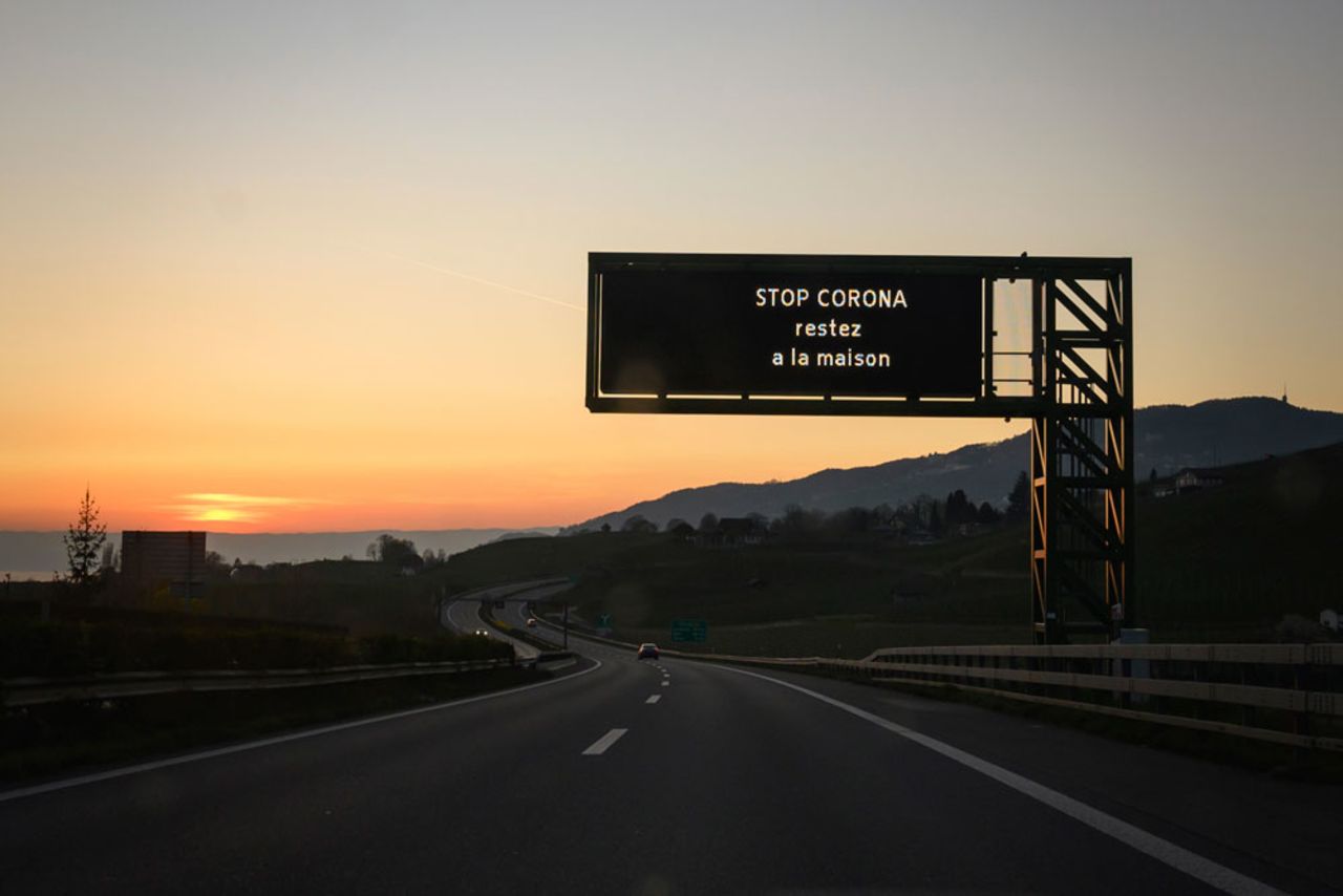 A traffic board reading in French "Stop corona, stay home" is seen at sunset on a motorway in Switzerland's municipality of Montreux on April 4.