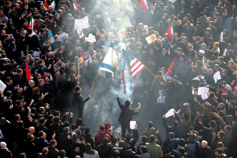 Iranians set a US and Israeli flag on fire during the funeral procession. 