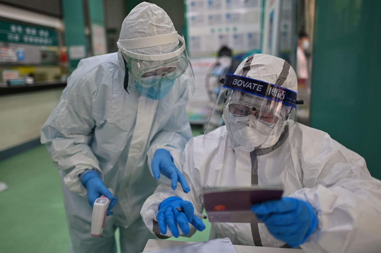 Medical workers check information as they take swab samples from people to be tested for the coronavirus in Wuhan, in China's central Hubei province on April 16. 