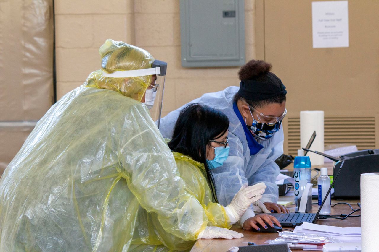 Medical workers with OptumServe Health Services prepare a Covid-19 test sample from a patient inside the National Guard Armory in La Porte, Indiana on May 6.