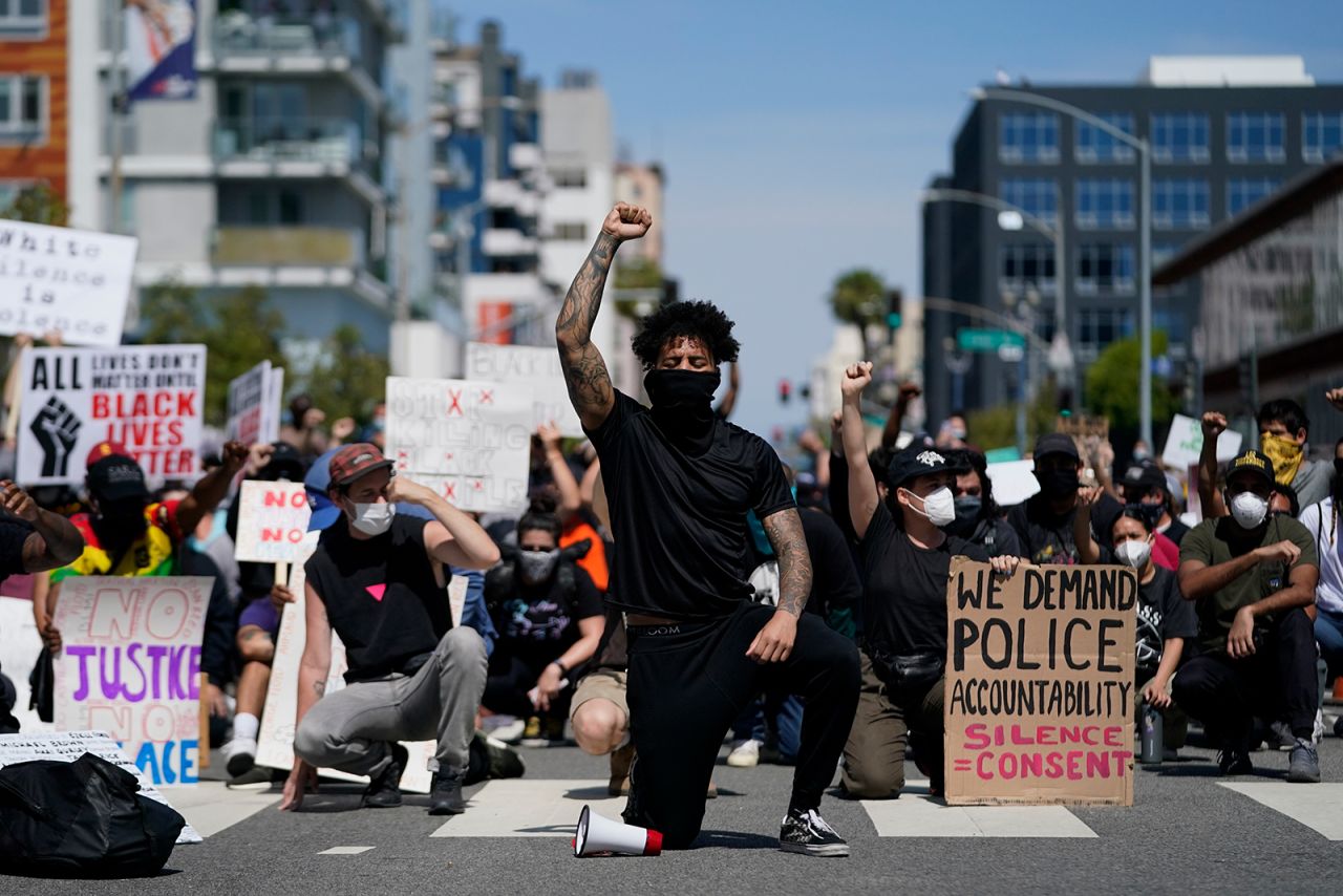 Demonstrators kneel in a moment of silence outside the Long Beach Police Department on Sunday, May 31 in Long Beach, California. 