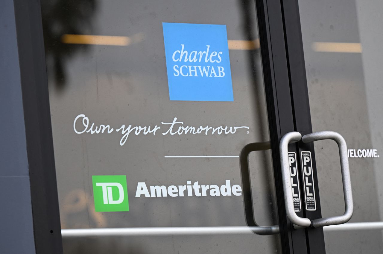 The Charles Schwab and TD Ameritrade logos are displayed on the door of a Charles Schwab Corporation branch in Torrance, California, on March 13, 2023.
