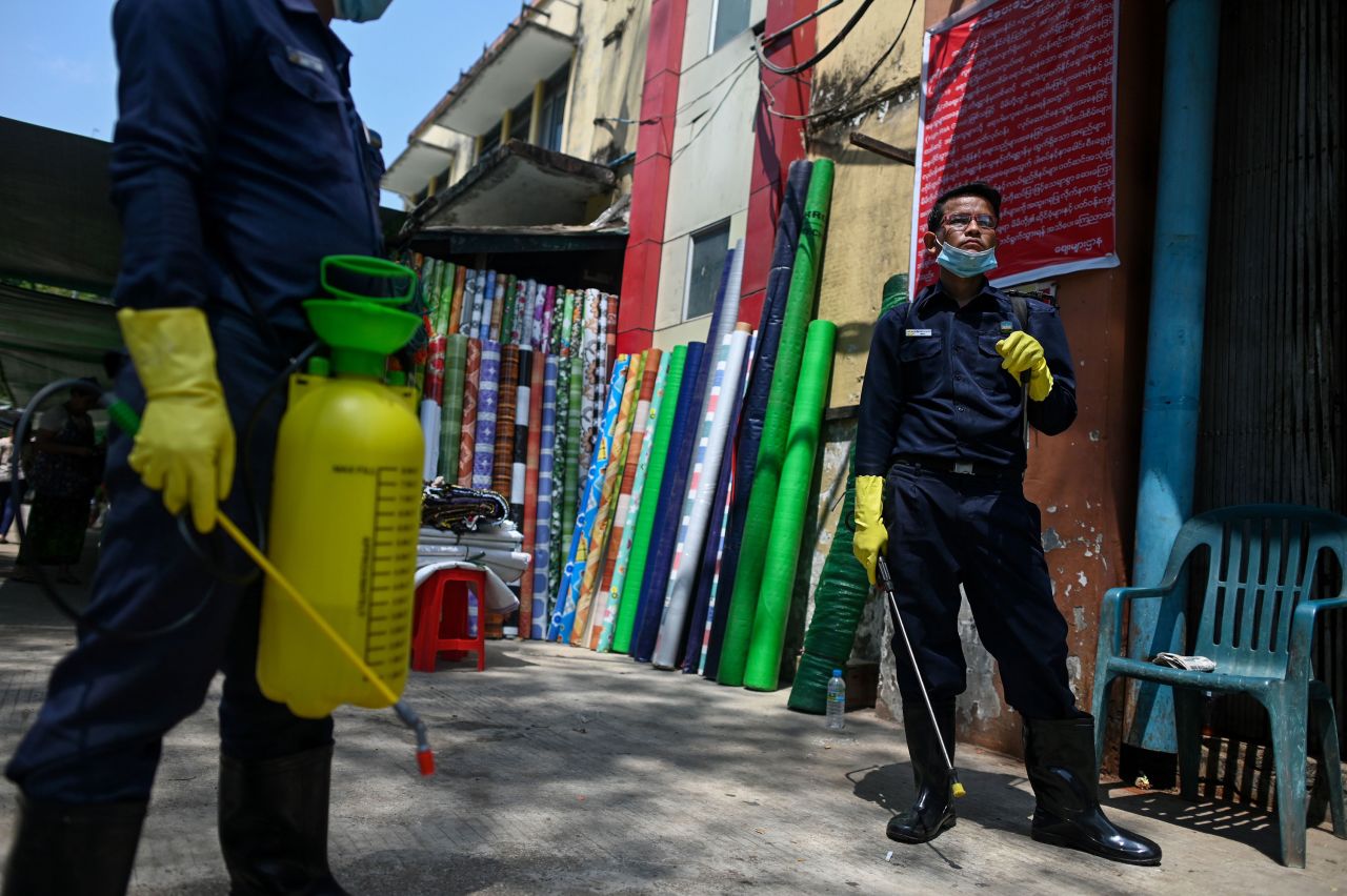 Staff members of the Yangon City Development Committee rest after disinfecting the Pazontaung market in Yangon, Myanmar on March 21.