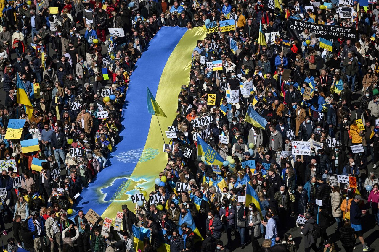 Demonstrators hold a giant Ukrainian flag during a protest against Russia's invasion of Ukraine on February 27, in Madrid, Spain. 