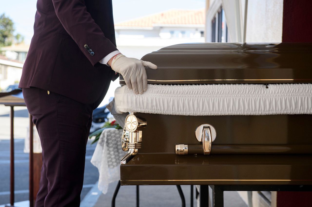 Funeral director Steven Correa moves the casket of Gilberto Arreguin Camacho, 58, in preparation for burial following his death due to Covid-19 at the Continental Funeral Home on December 31, in Los Angeles, California. 