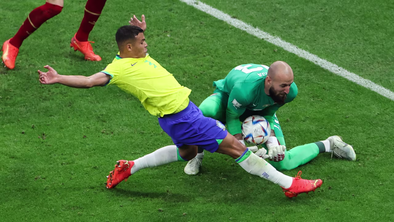 Serbian goalkeeper Vanja Milinkovic-Savic gathers the ball next to Brazil's Thiago Silva.