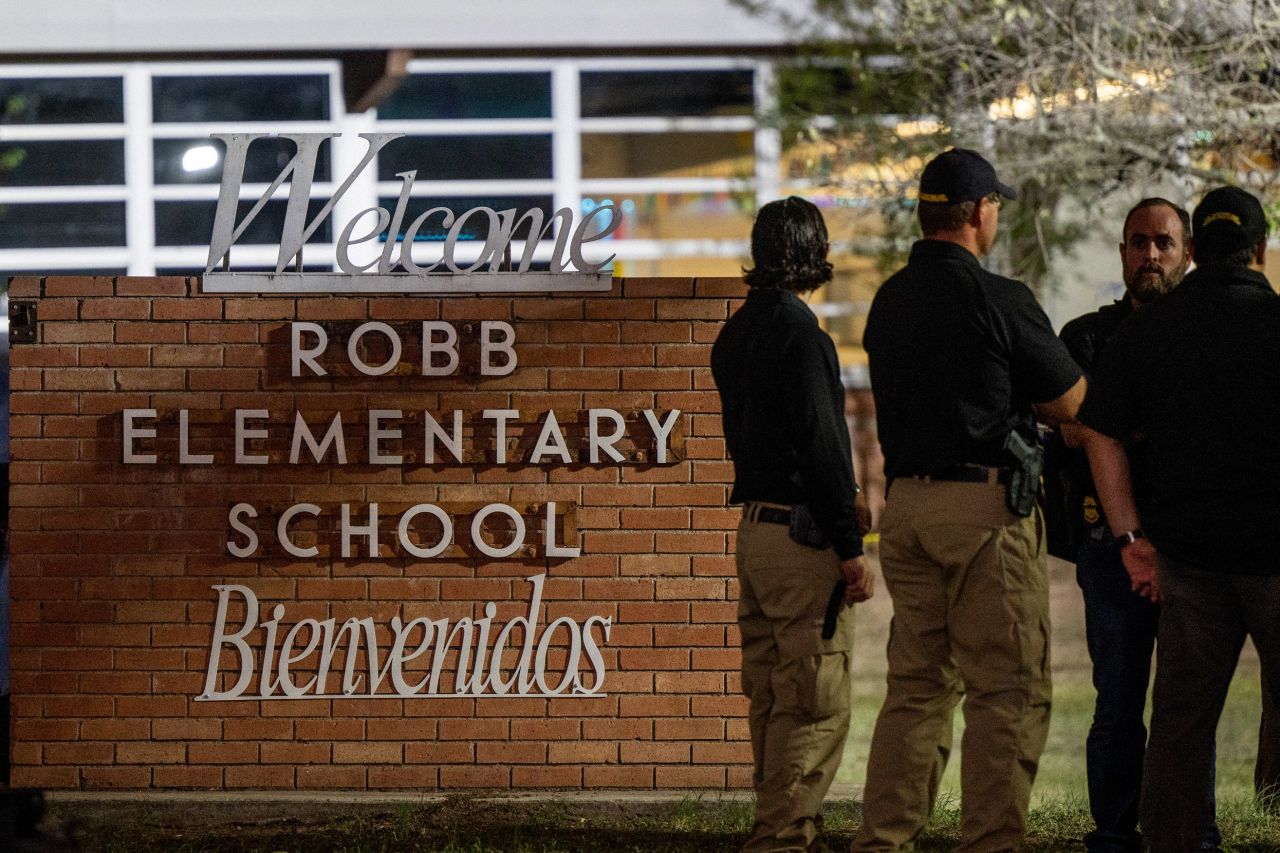 Law enforcement officers speak together outside of Robb Elementary School following the shooting on May 24, in Uvalde, Texas. 