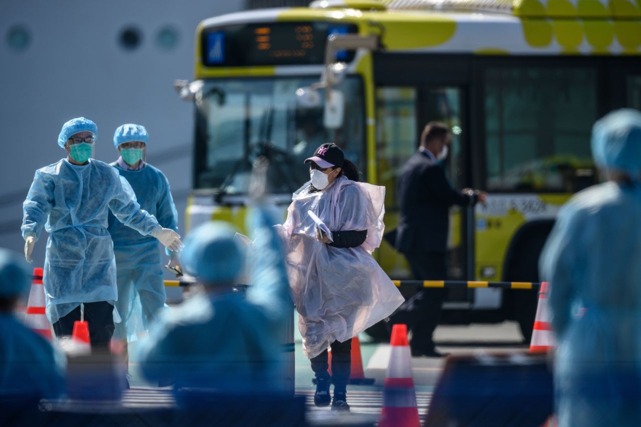 A mask-clad passenger heads for a temperature check after disembarking from the Diamond Princess cruise ship.