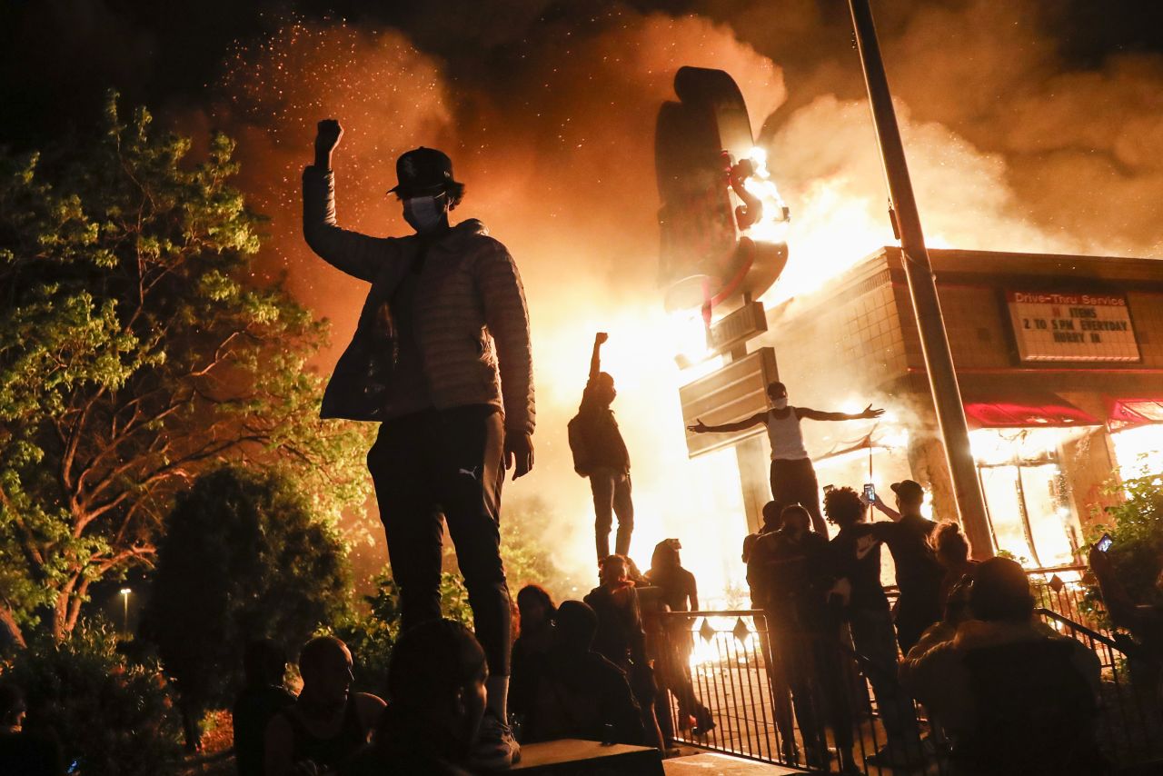 Protestors demonstrate outside a burning fast food restaurant in Minneapolis on May 29.