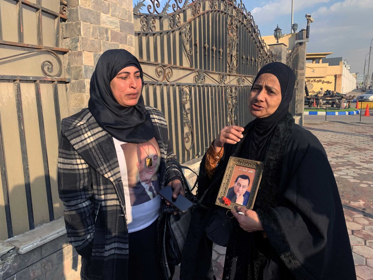 Supporters of former president Hosni Mubarak hold pictures of him outside a military hospital in Cairo on Tuesday, following the news of his death.
