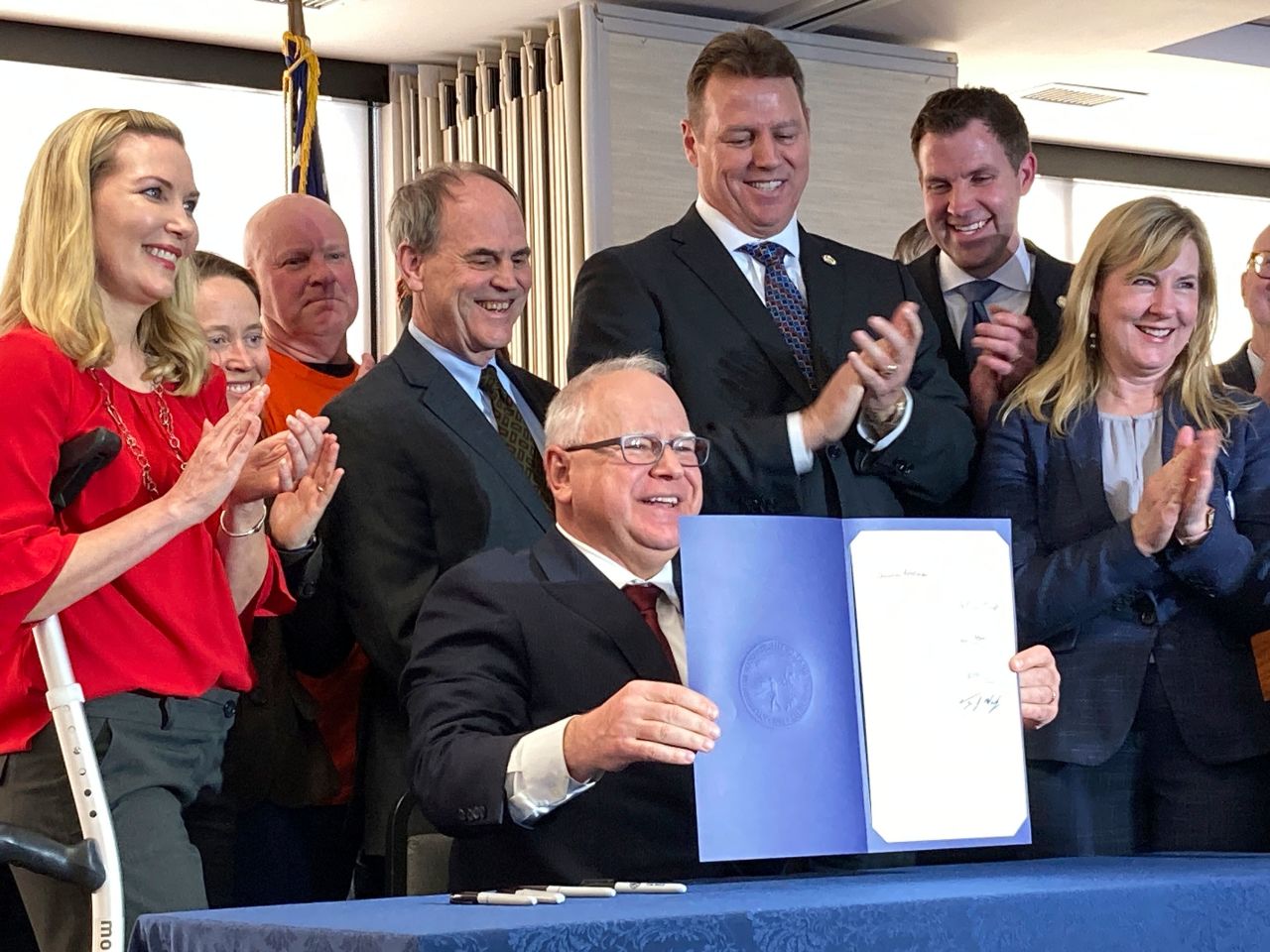 Minnesota Gov. Tim Walz displays a bill he signed into law in St. Paul, Minnesota, in February 2023. The bill required Minnesota utilities to get 100% of their electricity from carbon-free sources by 2040.