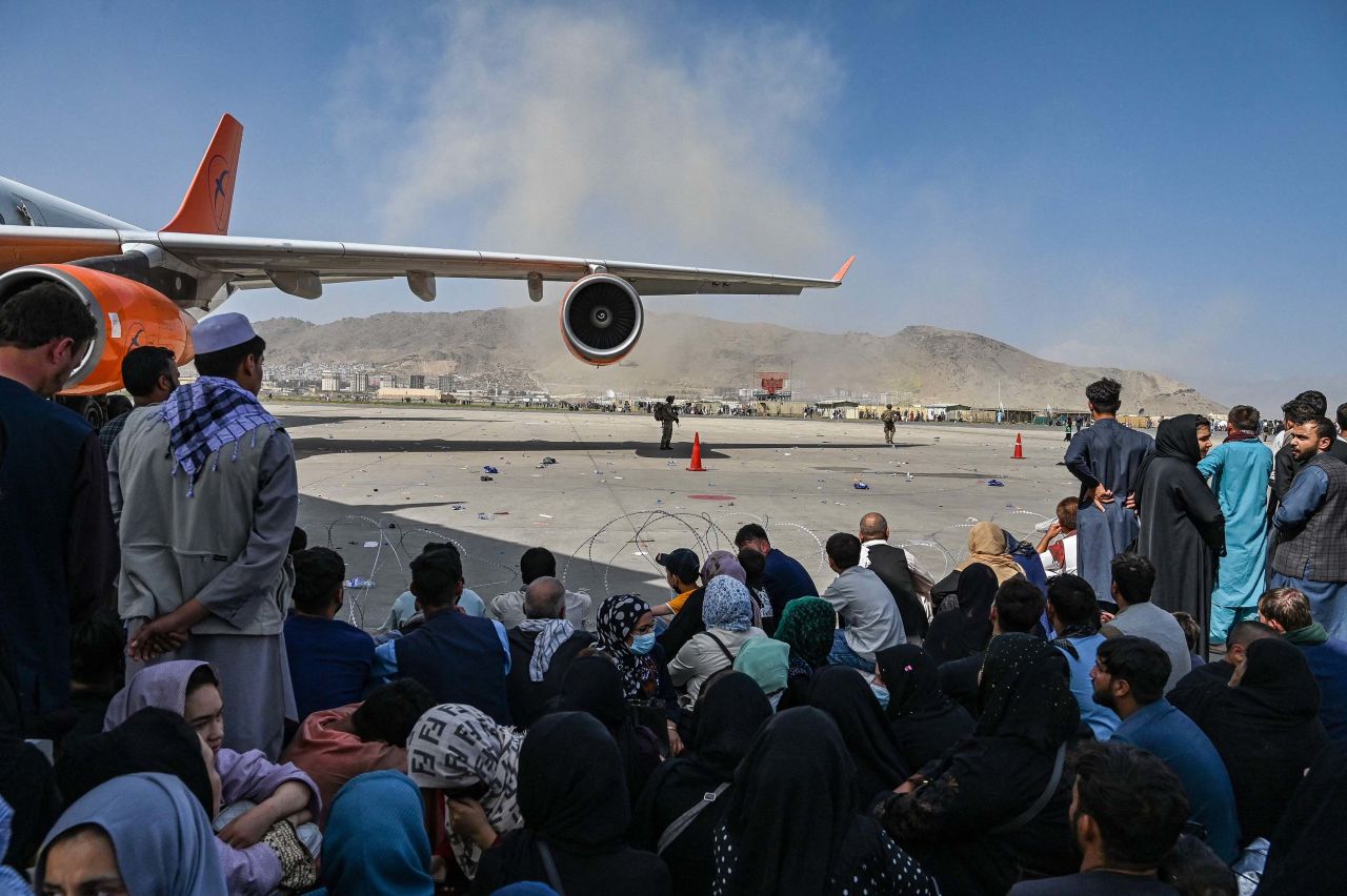 People wait to leave Kabul airport on August 16. 