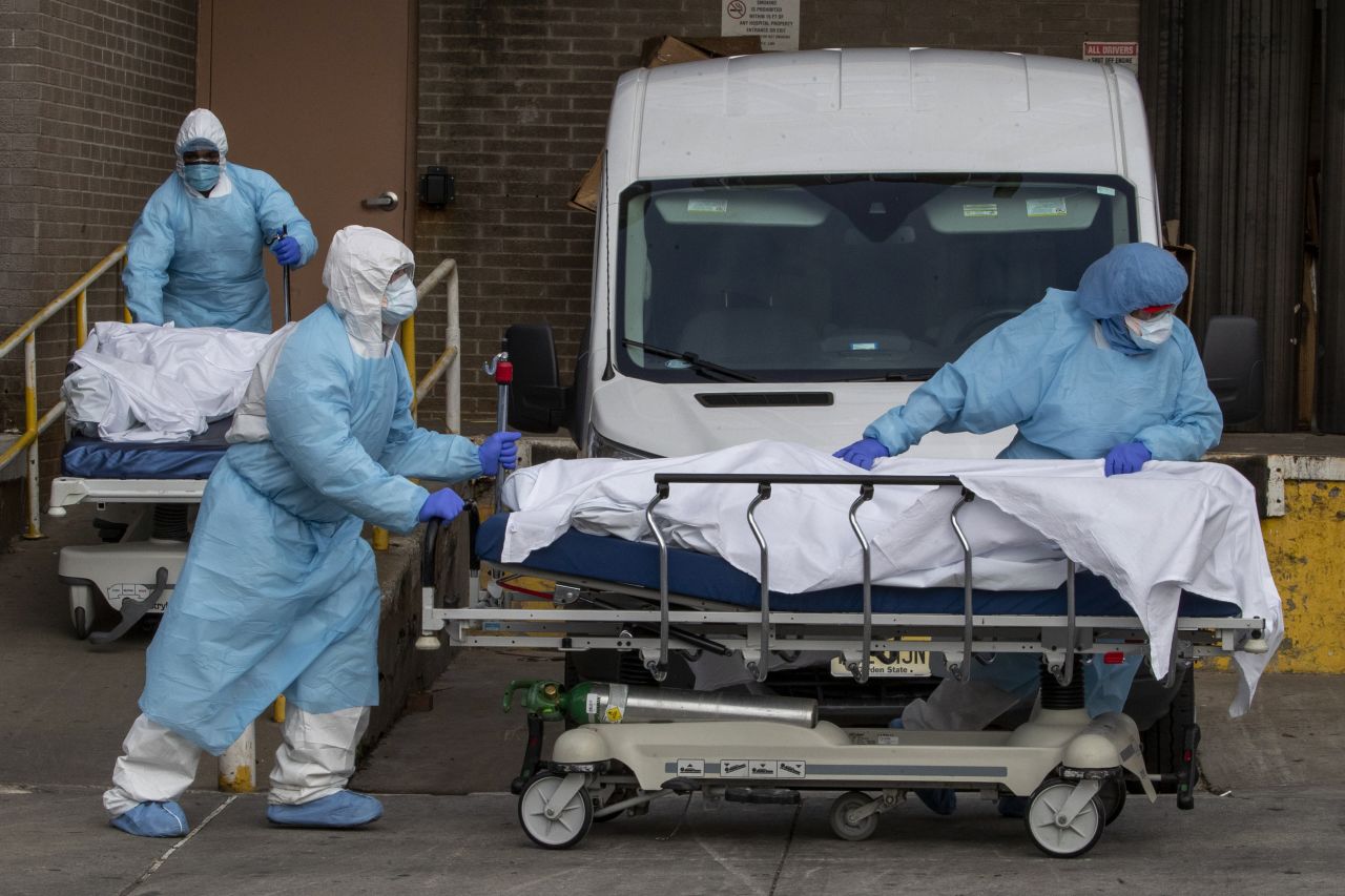 Medical personnel wearing personal protective equipment remove bodies from the Wyckoff Heights Medical Center Thursday, April 2, in the Brooklyn borough of New York.