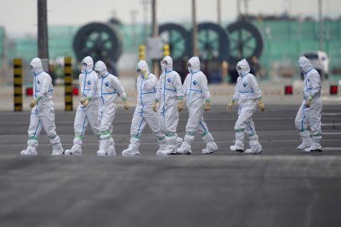 Workers in protective gear are seen near the Diamond Princess cruise ship docked in Yokohama, Japan on Friday.