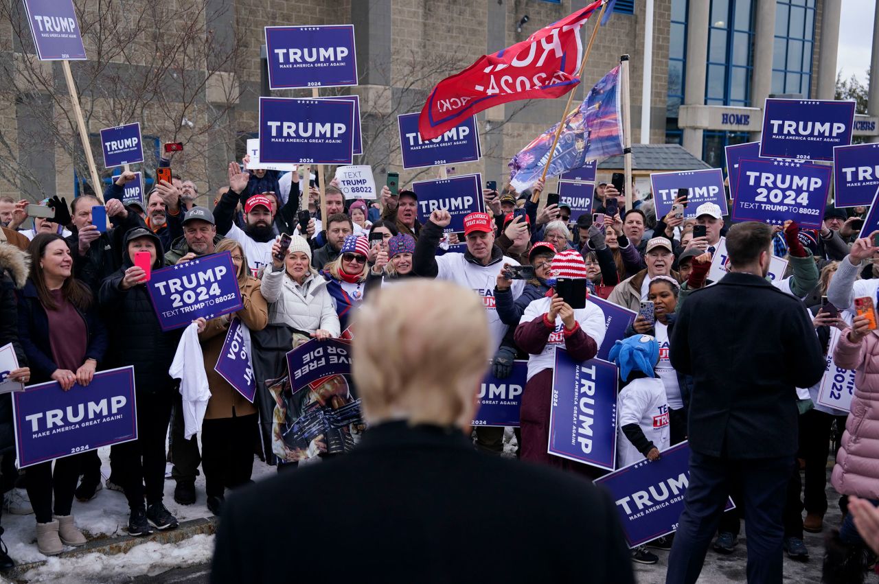 Former president Donald Trump greets supporters outside a polling location on Tuesday in Londonderry, New Hampshire.