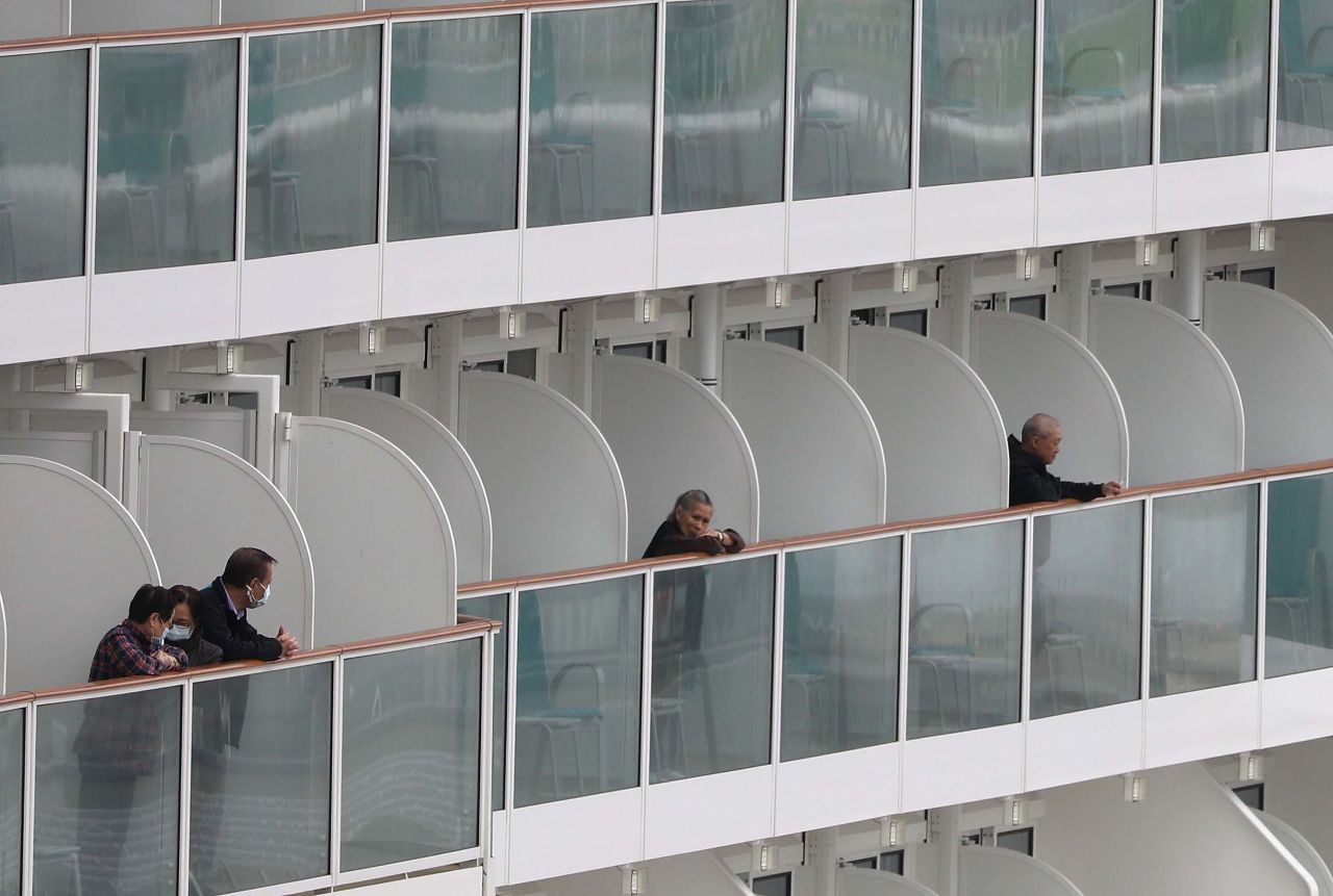 Passengers look out from balconies aboard the World Dream cruise liner docked at the Kai Tak Cruise Terminal in Hong Kong on Wednesday.