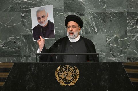 Iranian President Ebrahim Raisi holds a photo of late Iranian General Qasem Soleimani as addresses the 77th session of the United Nations General Assembly on Wednesday. 