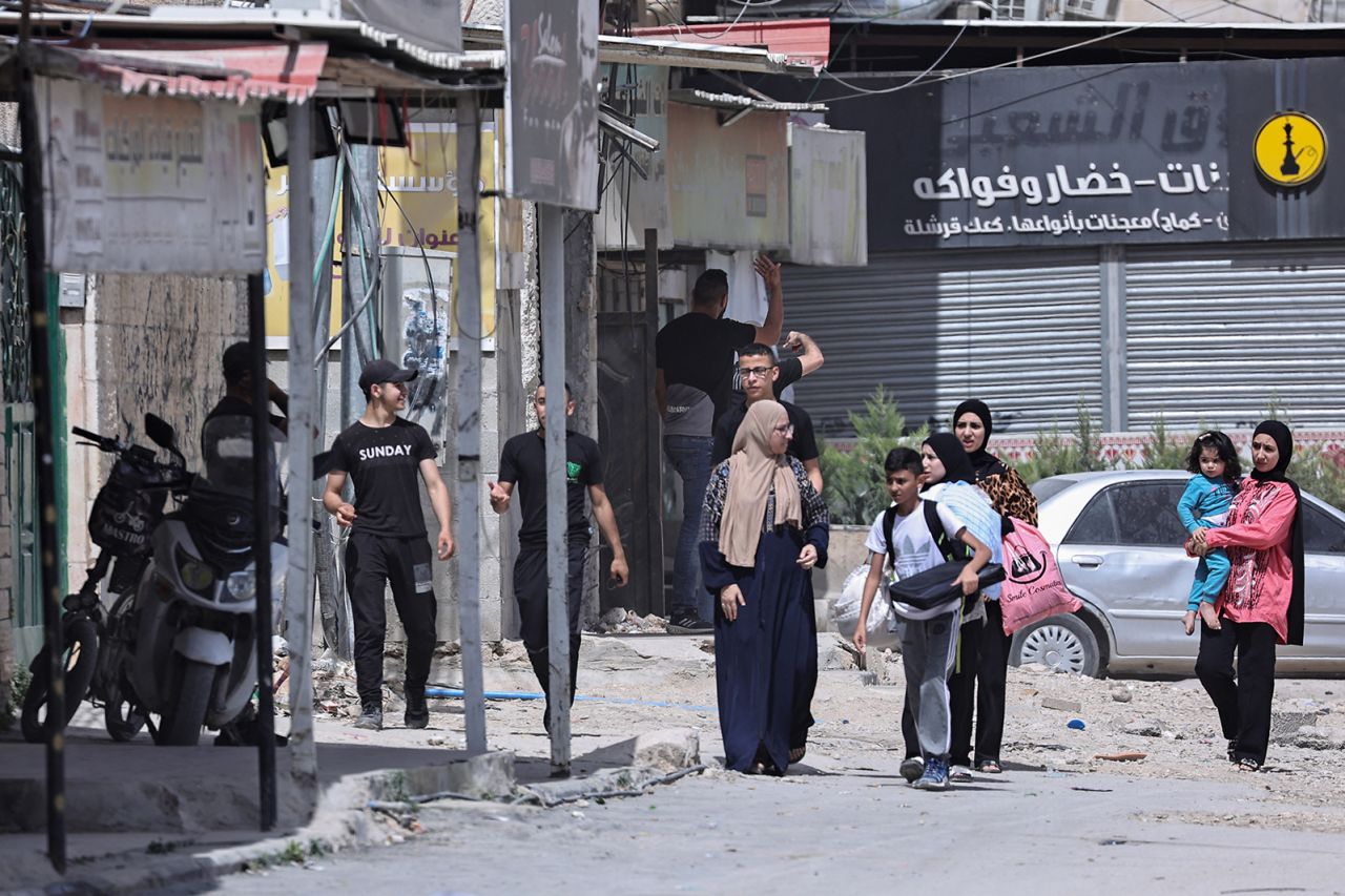 Palestinians gather on the side of a main street in front of closed shops during an Israeli army raid on Jenin in the occupied West Bank on May 21.