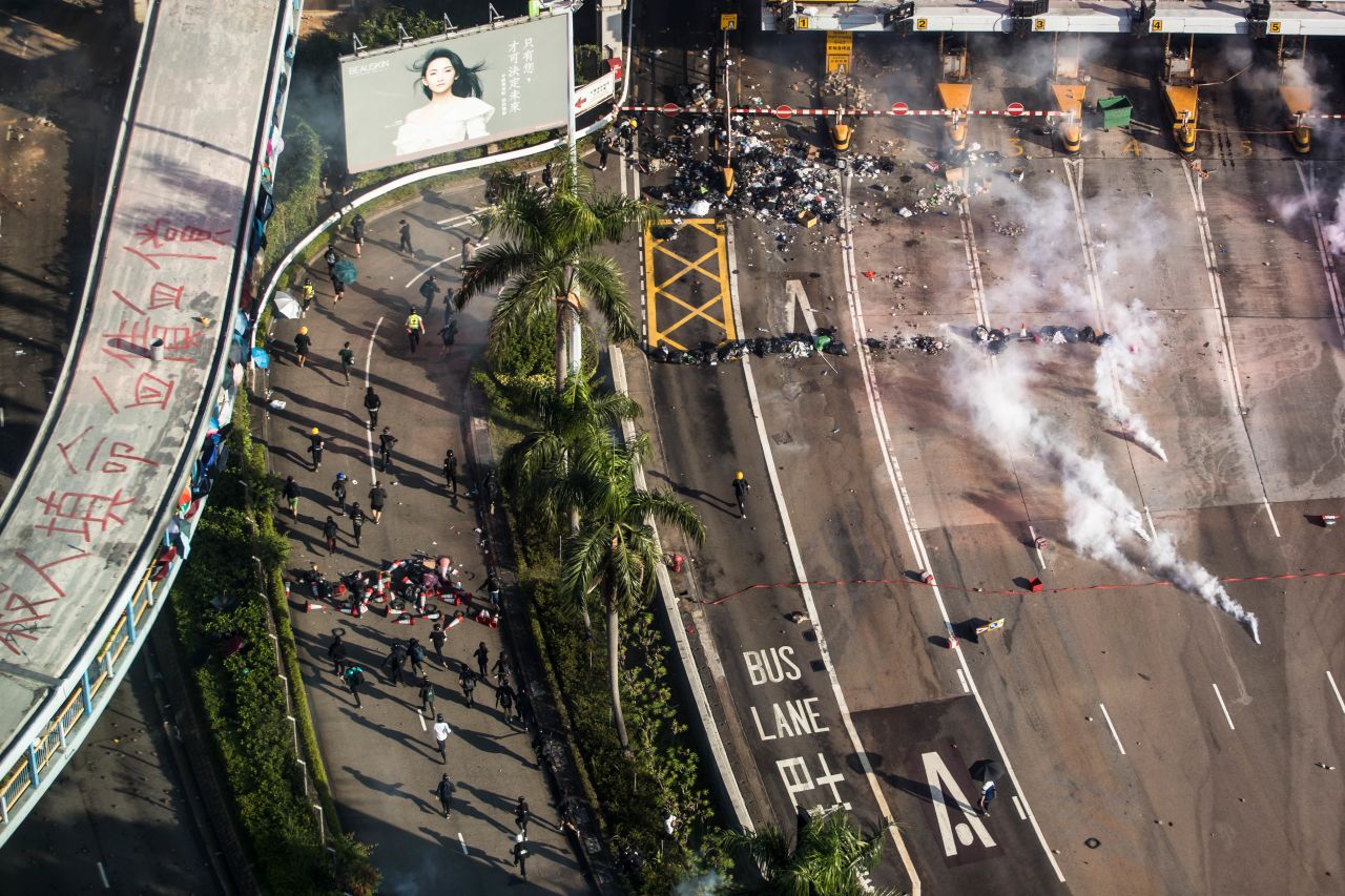 Police fire tear gas as protesters run on a road while trying to leave Hong Kong Polytechnic University in Hung Hom district of Hong Kong on November 18.