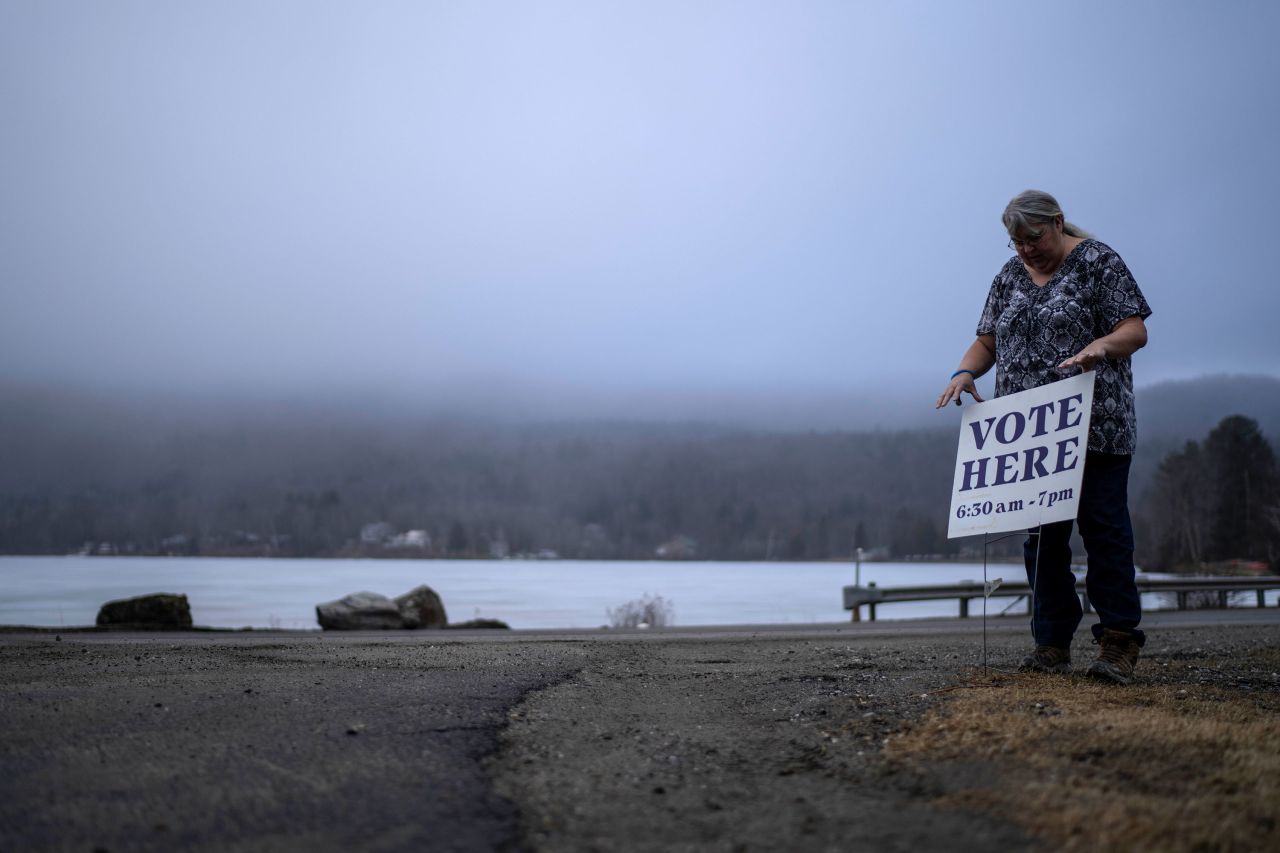 Town Clerk Sandra Lacasse places a sign outside the Elmore, Vermont, town office as polls open Tuesday morning.