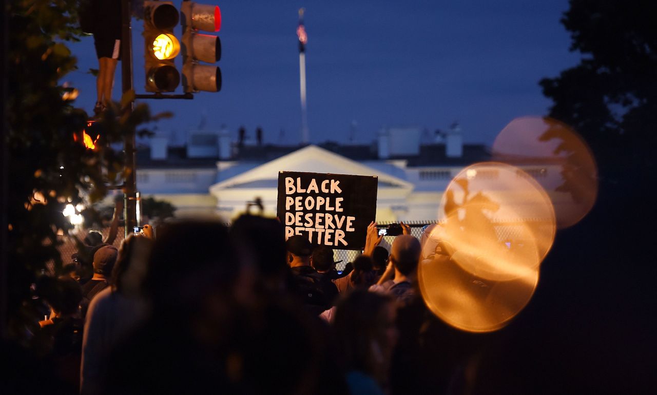 Demonstrators hold up placards near Lafayette park across from the White House on June 2 in Washington.