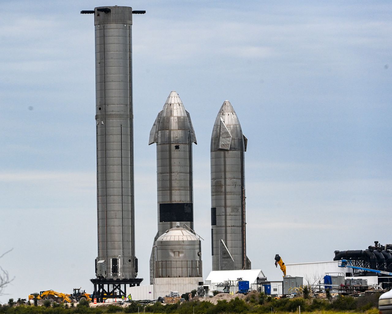 The Super Heavy booster, left, stands next to Starship spacecraft prototypes at the SpaceX launch facility in Boca Chica, Texas, in February 2022.