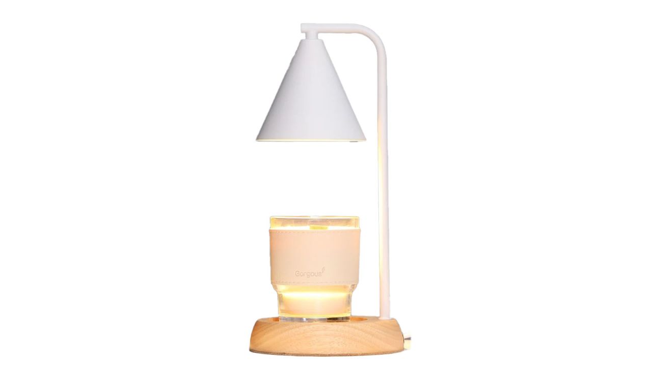 Candle warmer lamp with wooden base placed against white background.