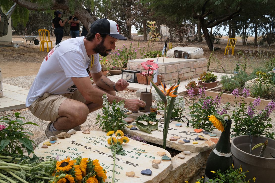 Daniel Lifshitz lights a candle on the grave of his best friend Dolev Yehud, who was a volunteer medic at kibbutz Nir Oz and was killed while trying to provide help to others in his community.