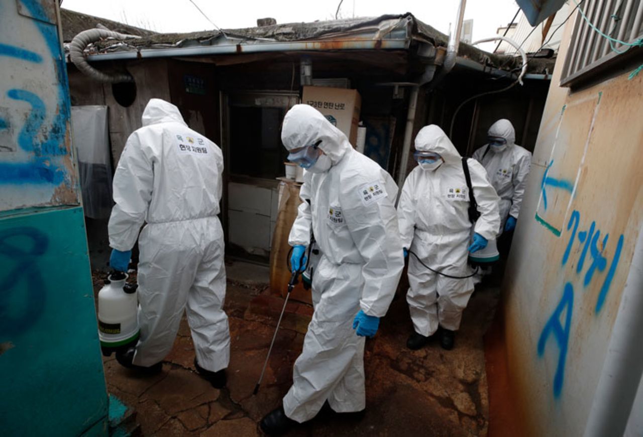 Soldiers wearing protective gear spray disinfectant in alleyways as a precaution against the new coronavirus in Seoul, South Korea, Tuesday, March 3.