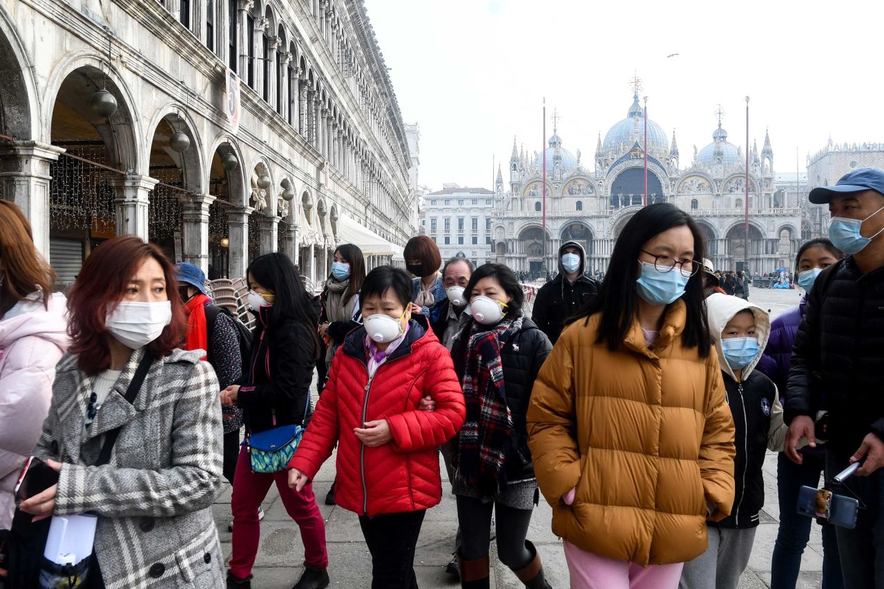 Tourists wearing protective face masks visit the Piazza San Marco in Venice, Italy on Monday.