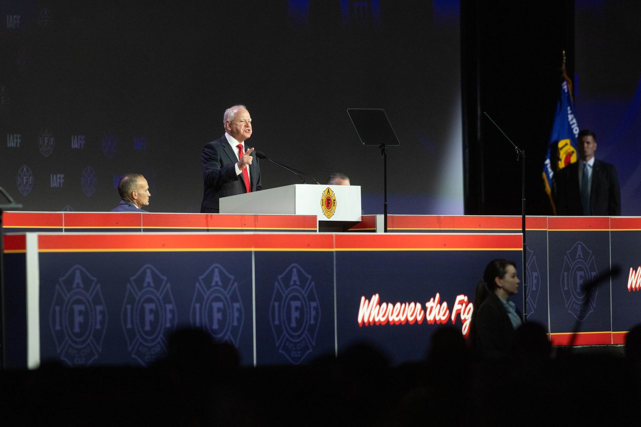 Minnesota Gov. Tim Walz speaks on stage during the International Association of Fire Fighters Convention on August 28 in Boston.