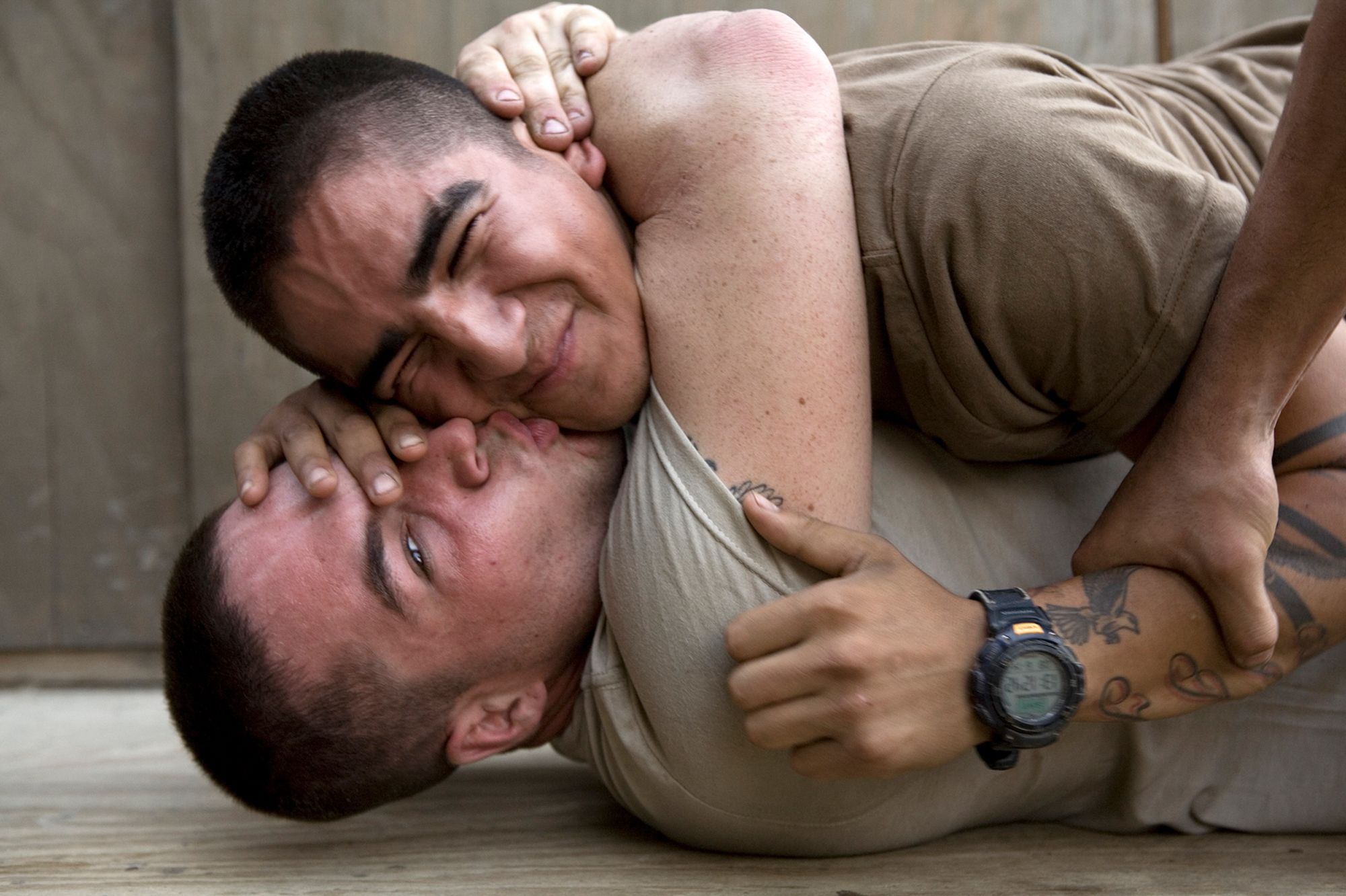 Bobby kisses Cortez during a play fight at the barracks of Second Platoon at the Korengal Outpost. Korengal Valley, Kunar Province, Afghanistan. June 2008.