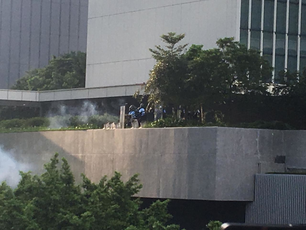 Police throw tear gas from a balcony in Admiralty.