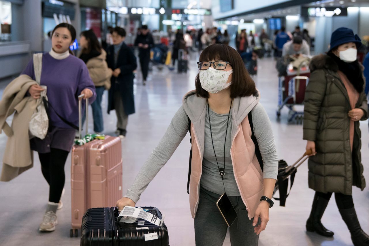 Passengers wearing masks arrive at Tokyo's Narita airport on January 24, 2020.