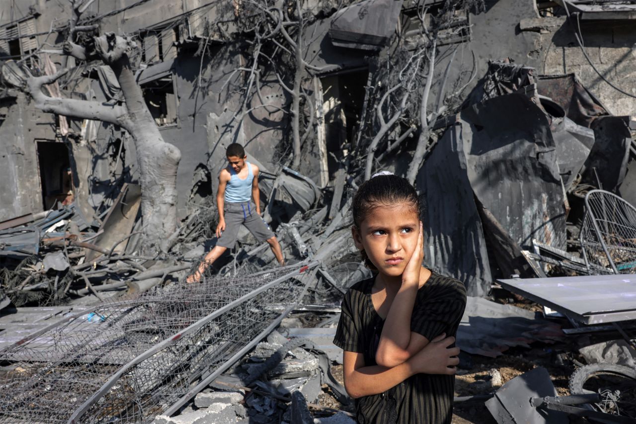 A girl looks on as she stands by the rubble outside of a building that was hit by Israeli bombardment in Rafah, southern Gaza, on October 31, 2023.