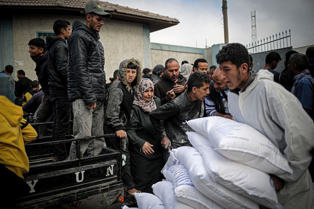 A Palestinian man transports sacks of humanitarian aid at the UNRWA distribution center, in Rafah, Gaza on March 3.