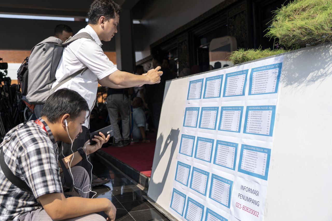 People photograph and look at the passenger manifest for Lion Air flight JT 610 at the crisis center at Soekarno-Hatta International Airport in Greater Jakarta.