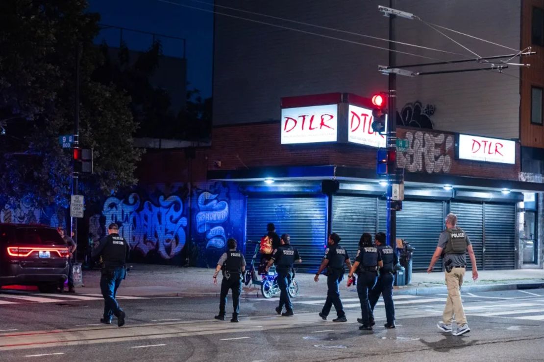Oficiales del Departamento de Policía Metropolitana, del Departamento de Policía de MetroTransit y un agente federal salen de un edificio de apartamentos tras responder a una llamada en el corredor de la calle H en Washington.