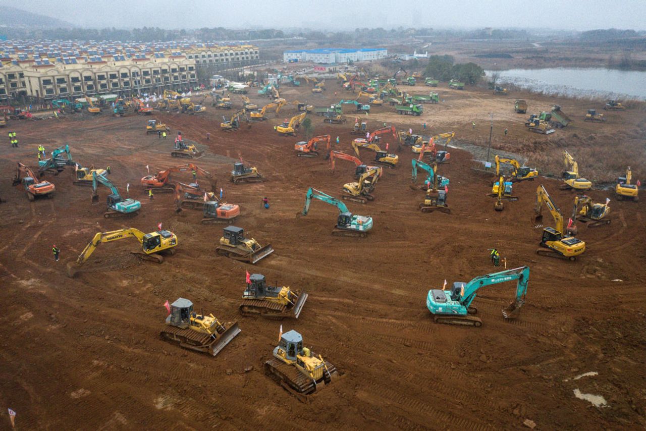 Construction workers drive excavators at the site of a new 1,000-bed hospital being built to accommodate the increasing number of coronavirus patients in Wuhan.