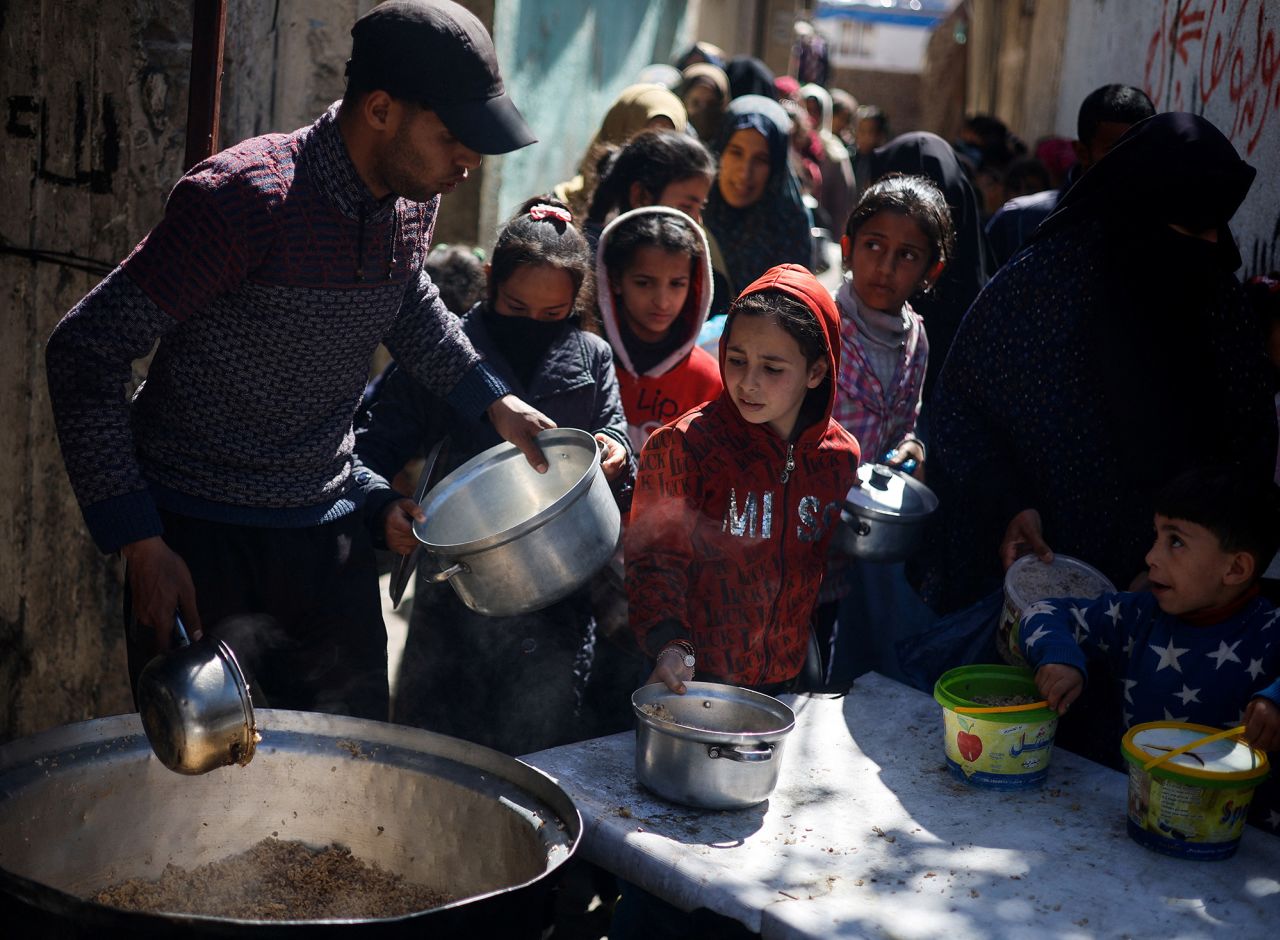 Palestinian children wait to receive food cooked by a charity kitchen amid shortages of food supplies in Rafah, Gaza, on March 5.