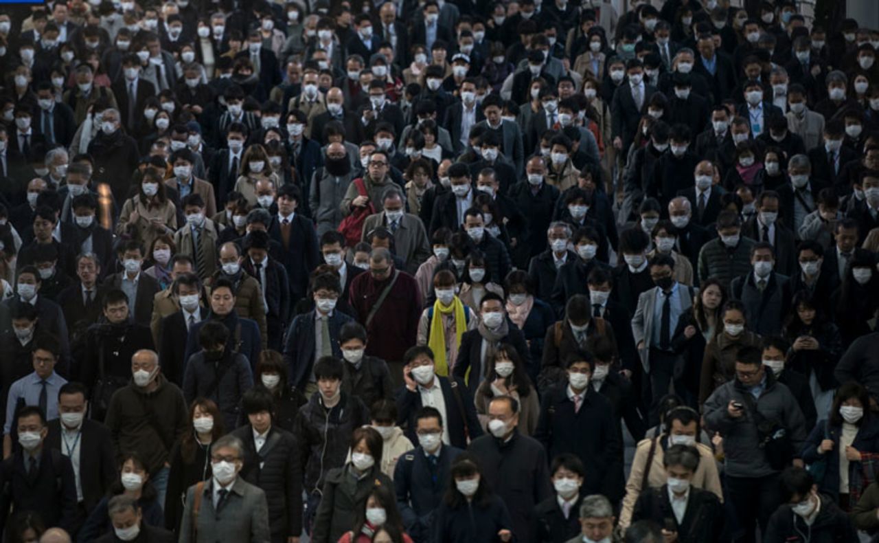 Commuters wearing face masks make their way to work on March 26 in Tokyo, Japan. 