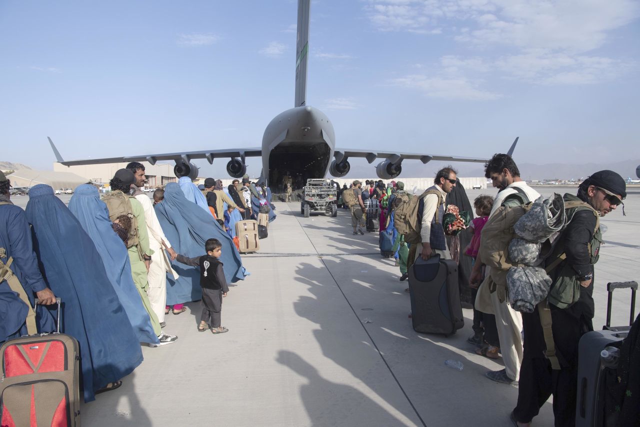 People being evacuated from Afghanistan queue to board an U.S. Air Force C-17 Globemaster III aircraft at Hamid Karzai International Airport on August 24.