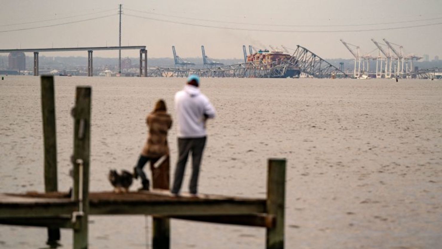 People look out toward the Francis Scott Key Bridge following its collapse in Baltimore, Maryland on March 26.