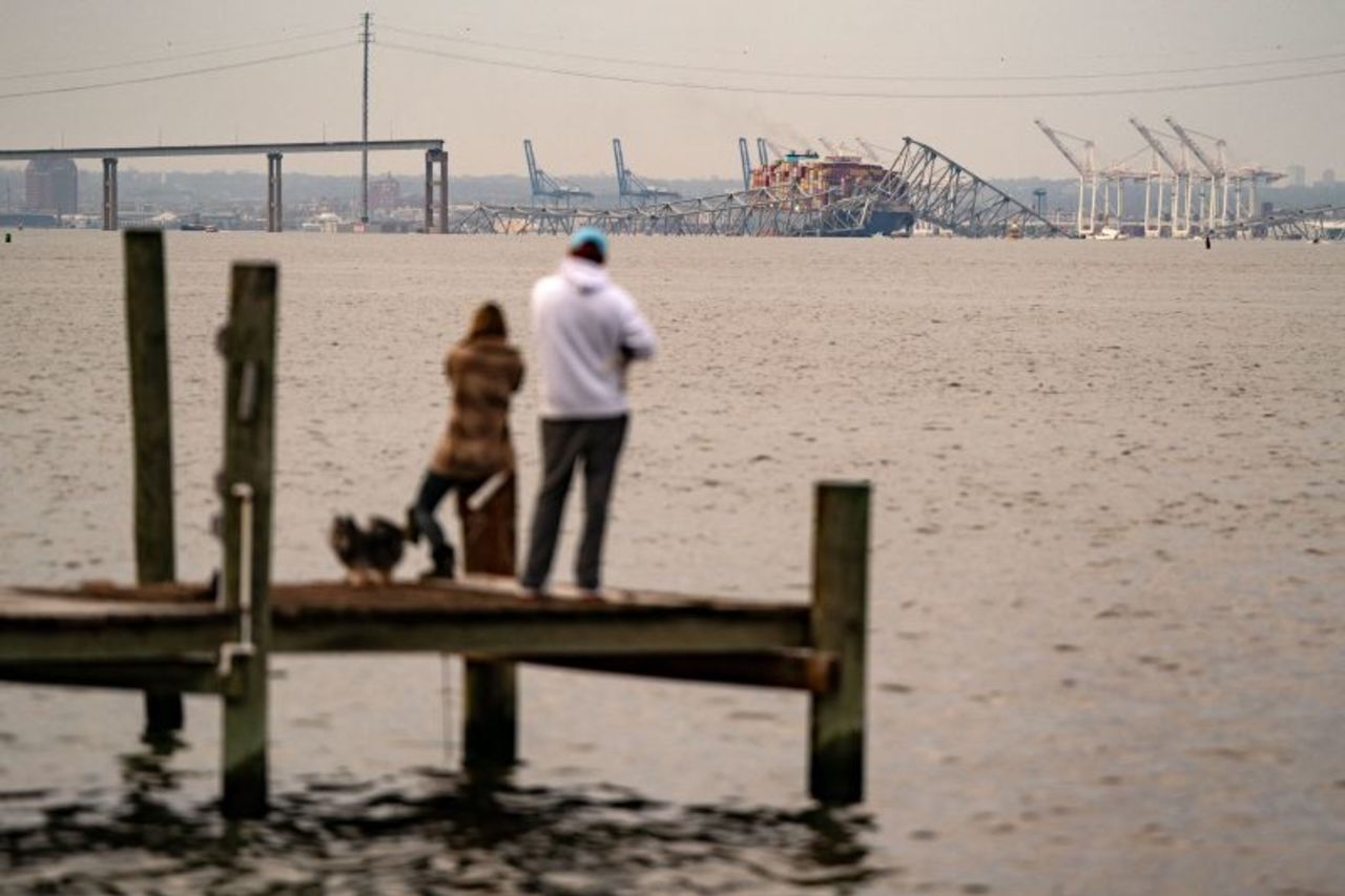 People look out toward the Francis Scott Key Bridge following its collapse in Baltimore, Maryland on March 26.