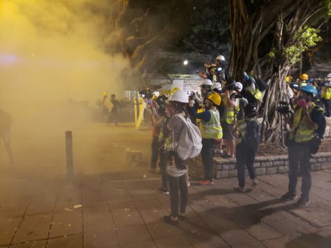Tear gas is fired at protesters surging forward. Ben Westcott/CNN